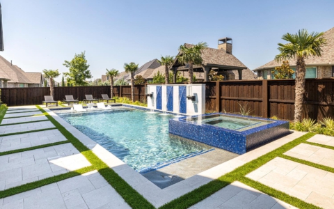 Geometric pool with water features and outdoor seating.