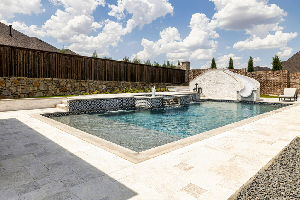 Geometric pool with water features and slide.